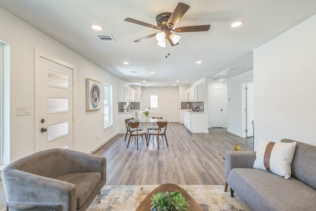 living room with light hardwood / wood-style flooring and ceiling fan