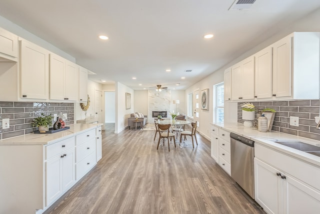 kitchen featuring white cabinets, ceiling fan, dishwasher, and light hardwood / wood-style flooring