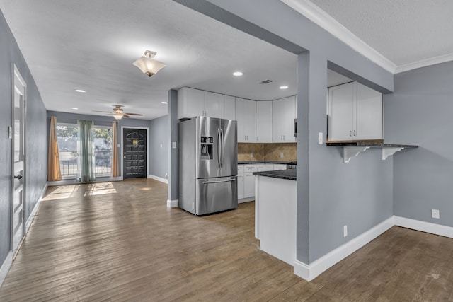 kitchen with stainless steel fridge, hardwood / wood-style flooring, ceiling fan, and white cabinets