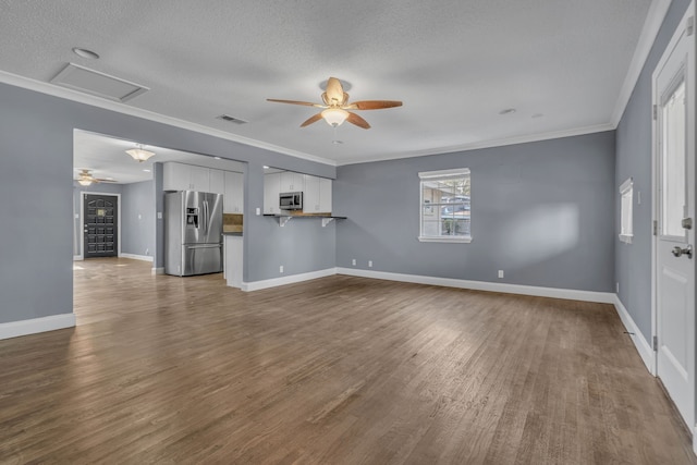 unfurnished living room with ceiling fan, a textured ceiling, wood-type flooring, and ornamental molding