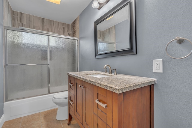 full bathroom with a wealth of natural light, vanity, toilet, and combined bath / shower with glass door