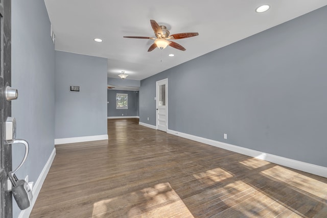 empty room with ceiling fan and dark hardwood / wood-style flooring