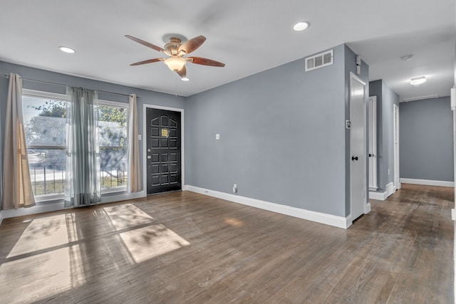 unfurnished room with dark wood-type flooring, ceiling fan, and a wealth of natural light