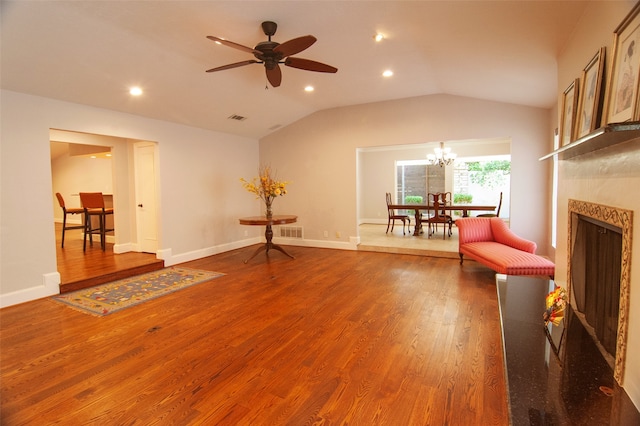 unfurnished room featuring ceiling fan with notable chandelier, vaulted ceiling, and dark hardwood / wood-style flooring