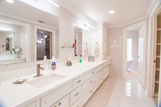 bathroom with ornamental molding, vanity, a bathing tub, and tile patterned floors