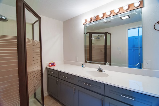 bathroom featuring tile patterned flooring, walk in shower, and vanity