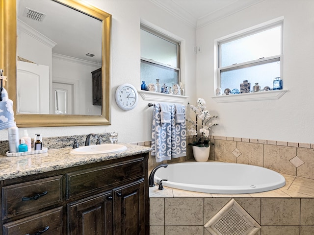 bathroom with tiled bath, crown molding, and vanity