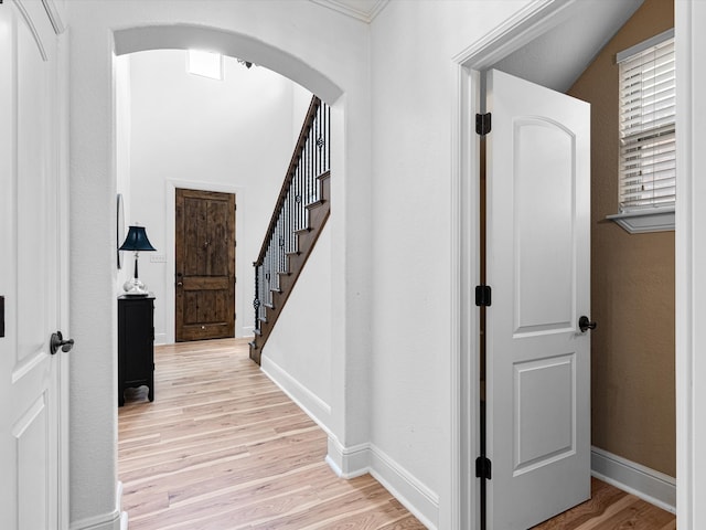 hallway with lofted ceiling and light hardwood / wood-style flooring