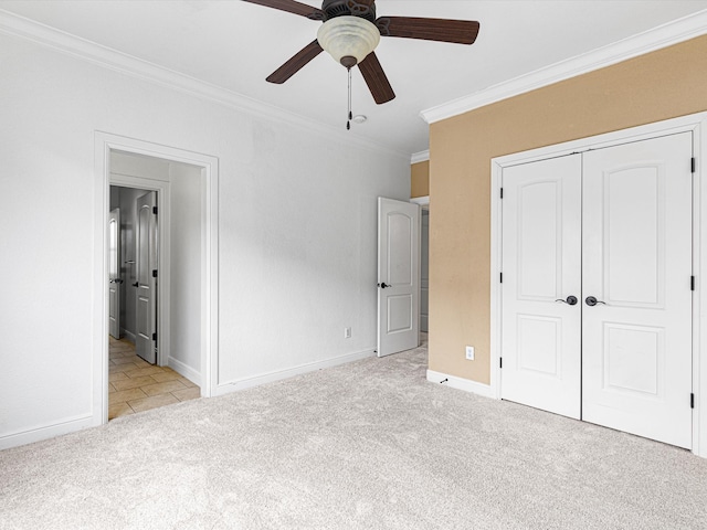 unfurnished bedroom featuring light carpet, a closet, ceiling fan, and ornamental molding