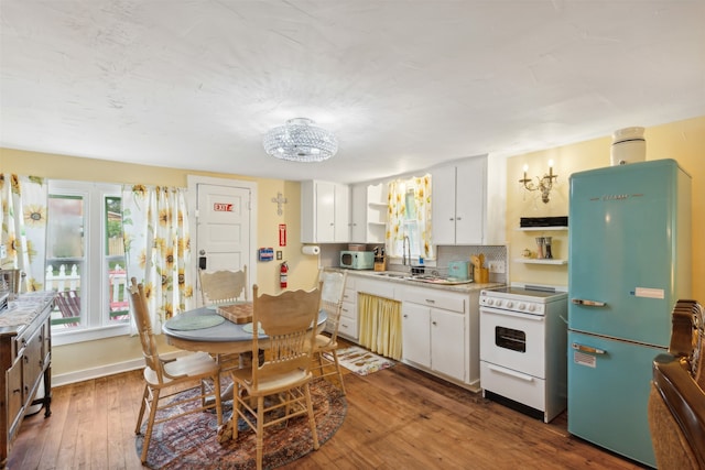 kitchen with white cabinets, stainless steel refrigerator, sink, white range with electric stovetop, and dark wood-type flooring