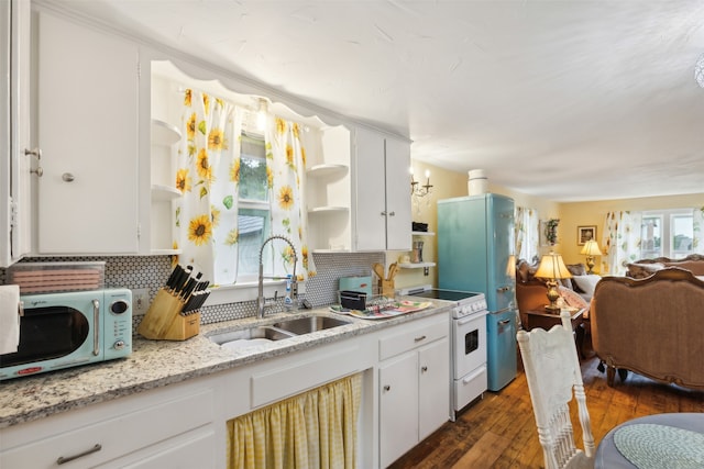 kitchen with dark hardwood / wood-style flooring, white appliances, plenty of natural light, and sink