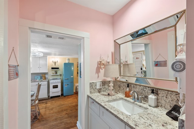 bathroom with vanity, wood-type flooring, and backsplash