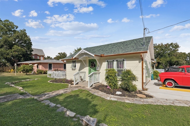 bungalow featuring a front lawn and a garage