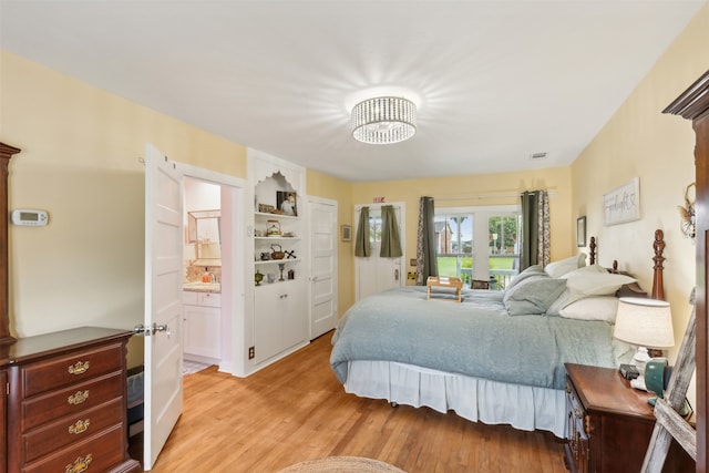 bedroom featuring connected bathroom and light hardwood / wood-style floors