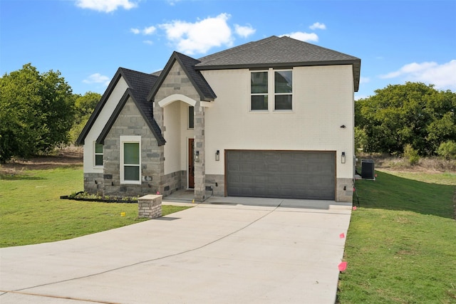 view of front of home with a front yard, concrete driveway, a garage, stone siding, and brick siding