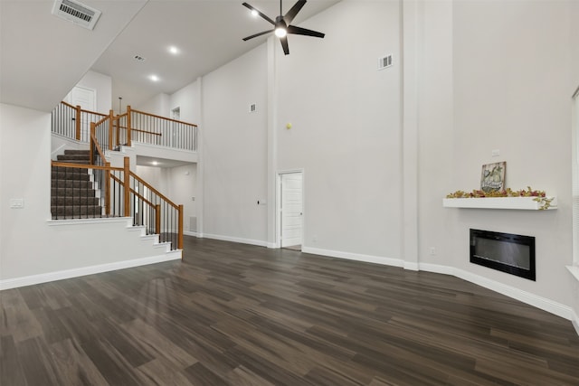 unfurnished living room featuring dark hardwood / wood-style flooring, high vaulted ceiling, and ceiling fan