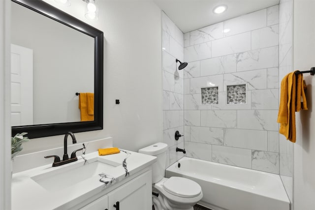 full bathroom featuring tiled shower / bath, toilet, and vanity