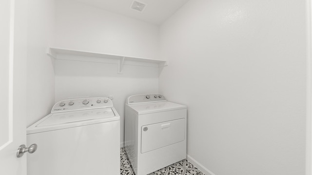 laundry room with washing machine and dryer and light tile patterned flooring