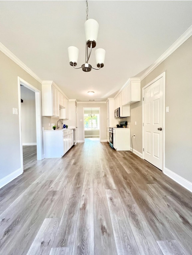 unfurnished living room with light wood-type flooring, ornamental molding, sink, and a chandelier