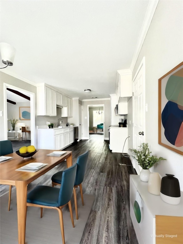 kitchen with white cabinets, crown molding, dark wood-type flooring, and sink