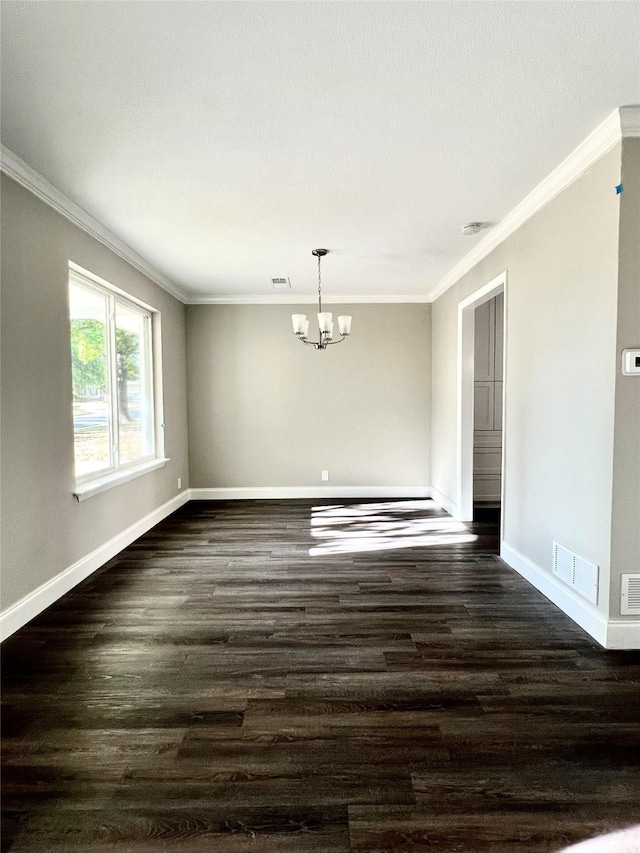 empty room with dark hardwood / wood-style floors, ornamental molding, and a chandelier