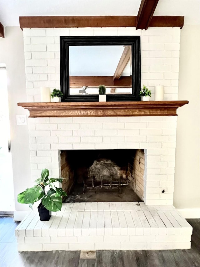 interior details featuring beam ceiling, a fireplace, and hardwood / wood-style floors