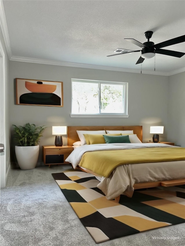 carpeted bedroom featuring ceiling fan, ornamental molding, and a textured ceiling