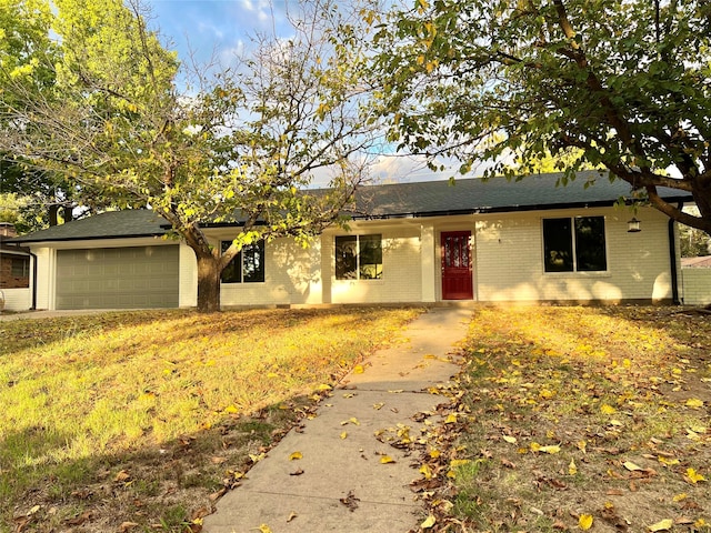 single story home featuring a garage and a front lawn