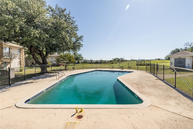 view of pool with a patio area and a yard