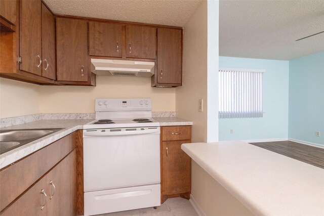104 Harbor Dr Unit 111, Runaway Bay, TX 76426 - kitchen with electric range, under cabinet range hood, a textured ceiling, brown cabinetry, and light countertops