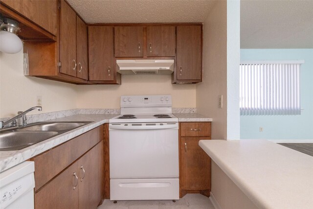 104 Harbor Dr Unit 111, Runaway Bay, TX 76426 - kitchen featuring white appliances, under cabinet range hood, a sink, brown cabinetry, and light countertops