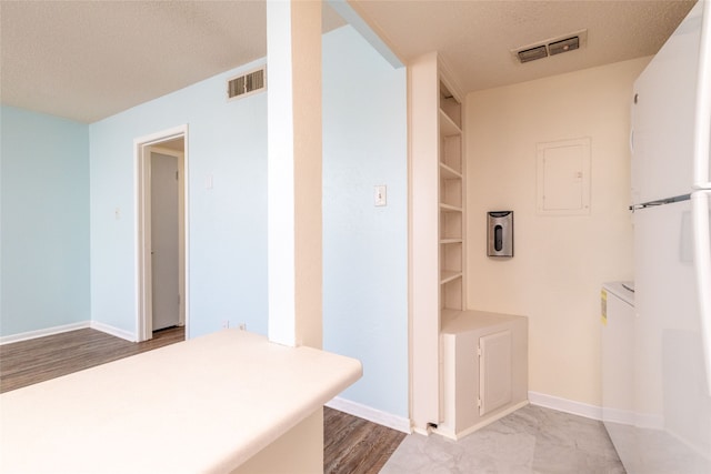 bathroom with a textured ceiling and wood-type flooring