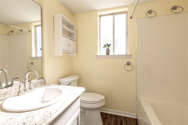104 Harbor Dr Unit 111, Runaway Bay, TX 76426 - full bathroom with toilet, baseboards, wood finished floors, vanity, and bathtub / shower combination