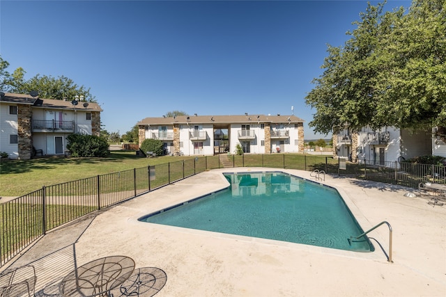 view of swimming pool featuring a yard