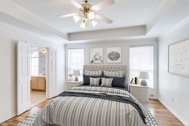 bedroom featuring multiple windows, ceiling fan, connected bathroom, and light hardwood / wood-style floors