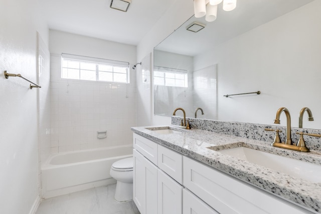 full bathroom featuring tiled shower / bath combo, vanity, and toilet