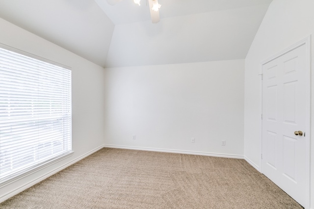 carpeted empty room with vaulted ceiling and ceiling fan