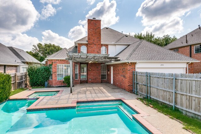 rear view of house with a pergola, a patio area, and a swimming pool with hot tub