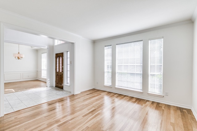 interior space with ornamental molding, light hardwood / wood-style flooring, and a notable chandelier