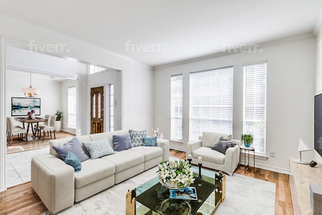 living room with a notable chandelier, wood-type flooring, and crown molding