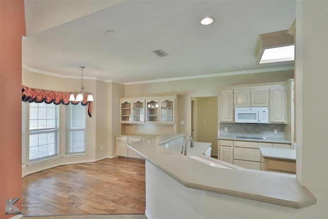 kitchen with crown molding, light wood-type flooring, a chandelier, and electric stovetop