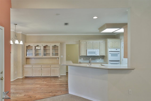 kitchen featuring ornamental molding, white appliances, a chandelier, light hardwood / wood-style flooring, and decorative light fixtures