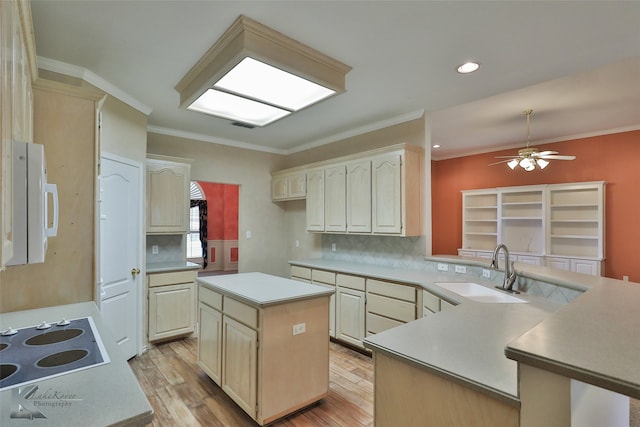 kitchen featuring light wood-type flooring, electric cooktop, sink, ceiling fan, and a kitchen island