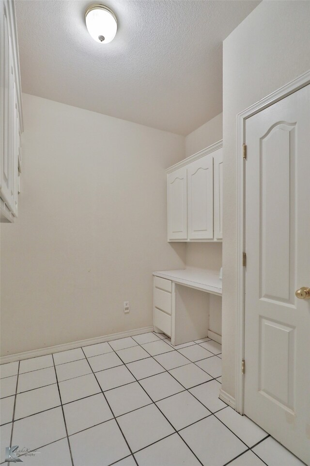 laundry room featuring light tile patterned floors and a textured ceiling