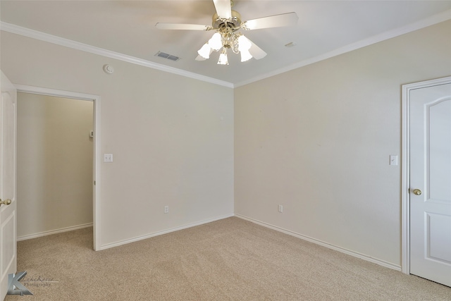 carpeted spare room with ceiling fan and ornamental molding