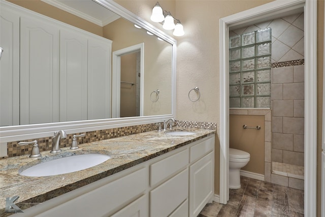 bathroom with toilet, wood-type flooring, vanity, tiled shower, and ornamental molding