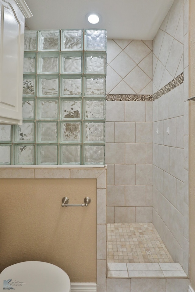 bathroom with toilet and a tile shower