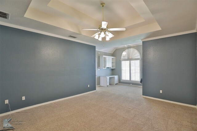 spare room featuring crown molding, a raised ceiling, ceiling fan, and carpet floors