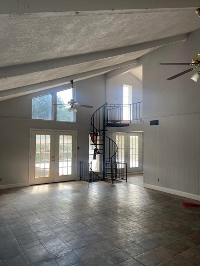 unfurnished living room featuring french doors, high vaulted ceiling, plenty of natural light, and ceiling fan