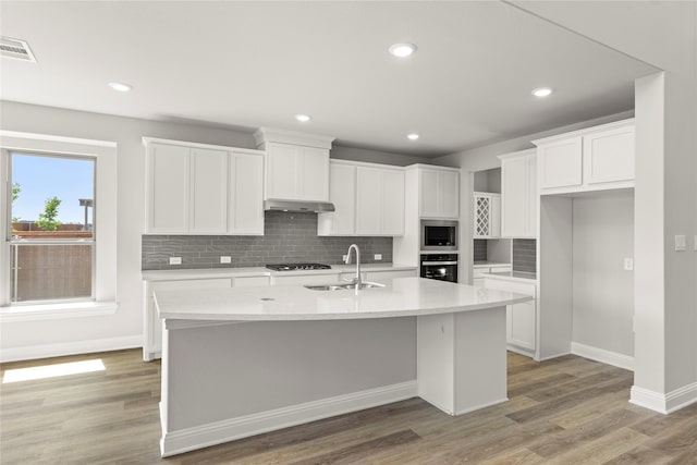4100 Pond Cypress St, Aubrey, TX 76227 - kitchen featuring oven, a sink, stainless steel microwave, baseboards, and under cabinet range hood